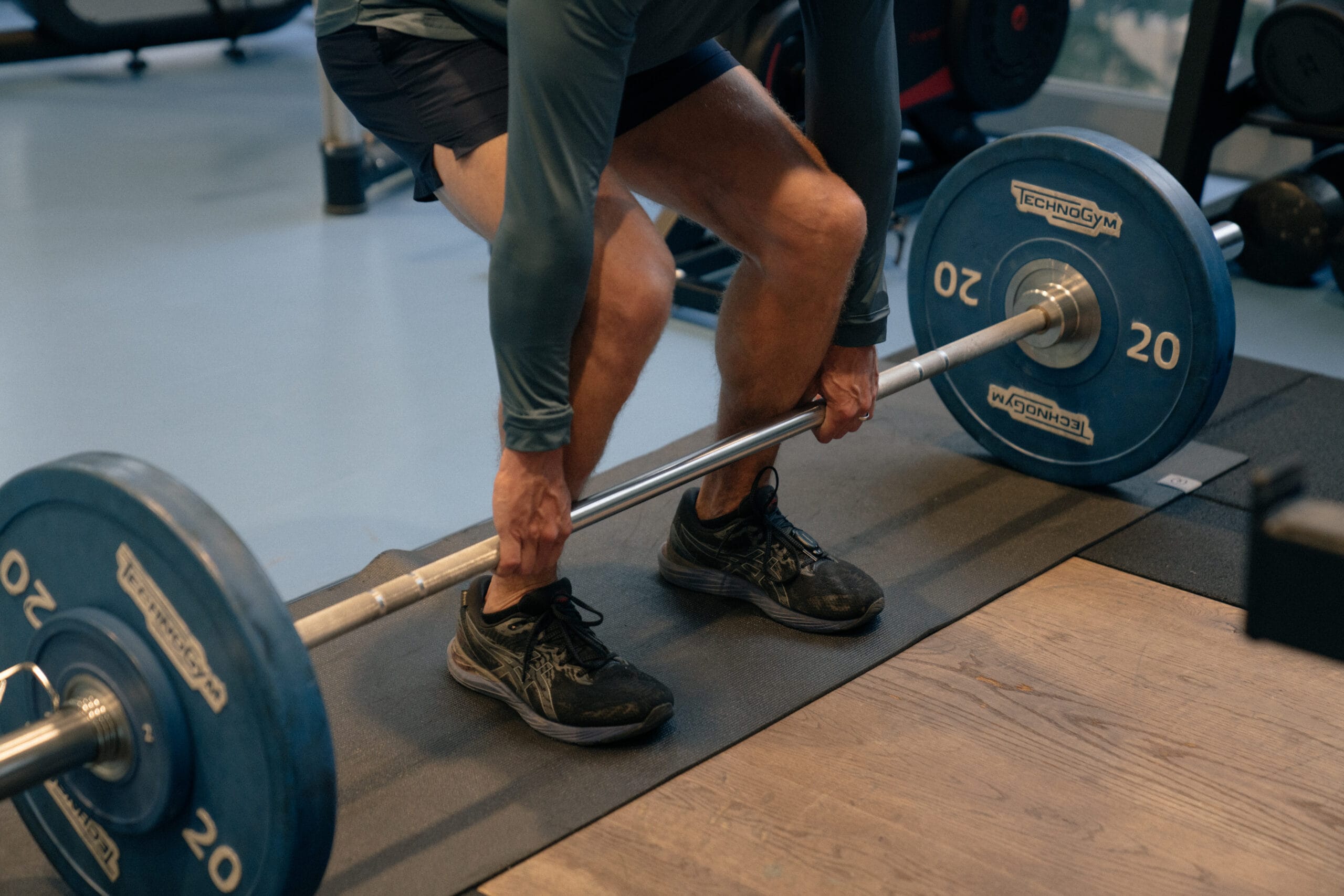 man lifting weight with knees bent for strength and conditioning