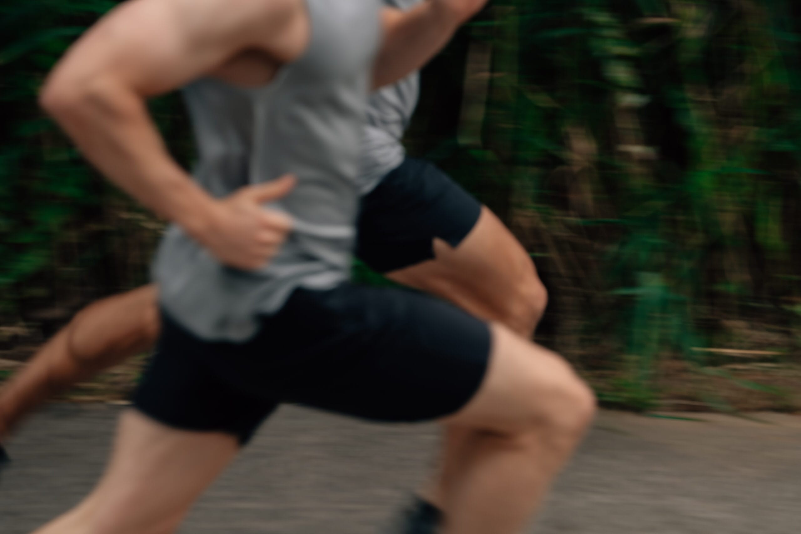 close up of men running in shorts