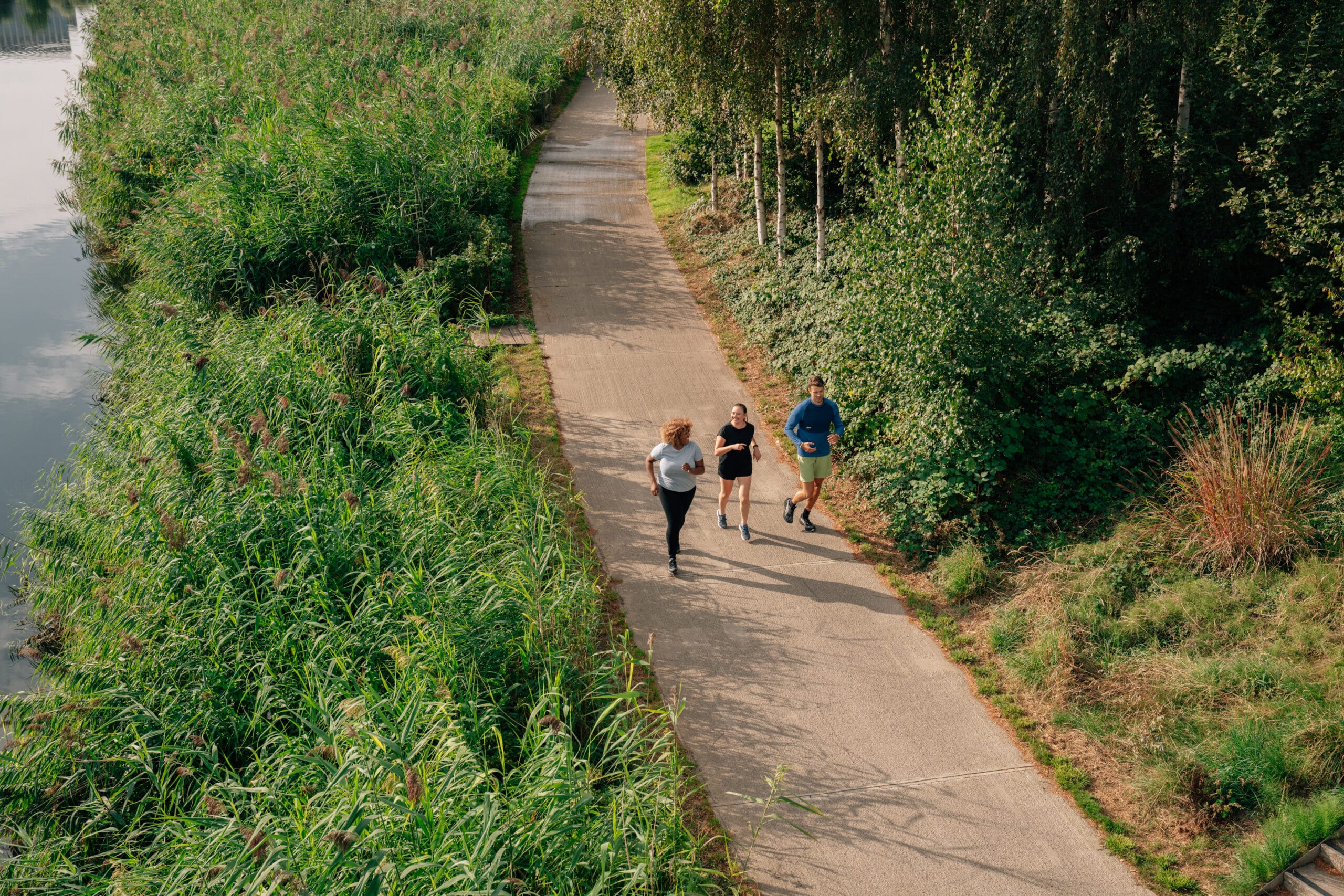 three people running in the distance on a path