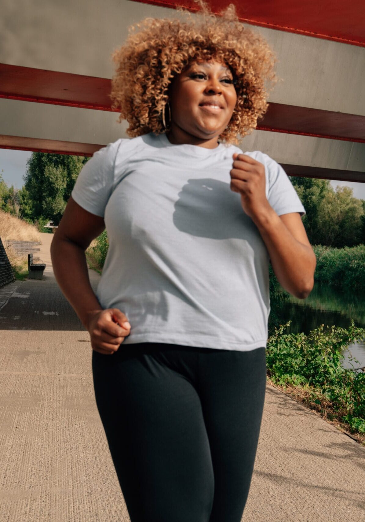 woman running under a bridge