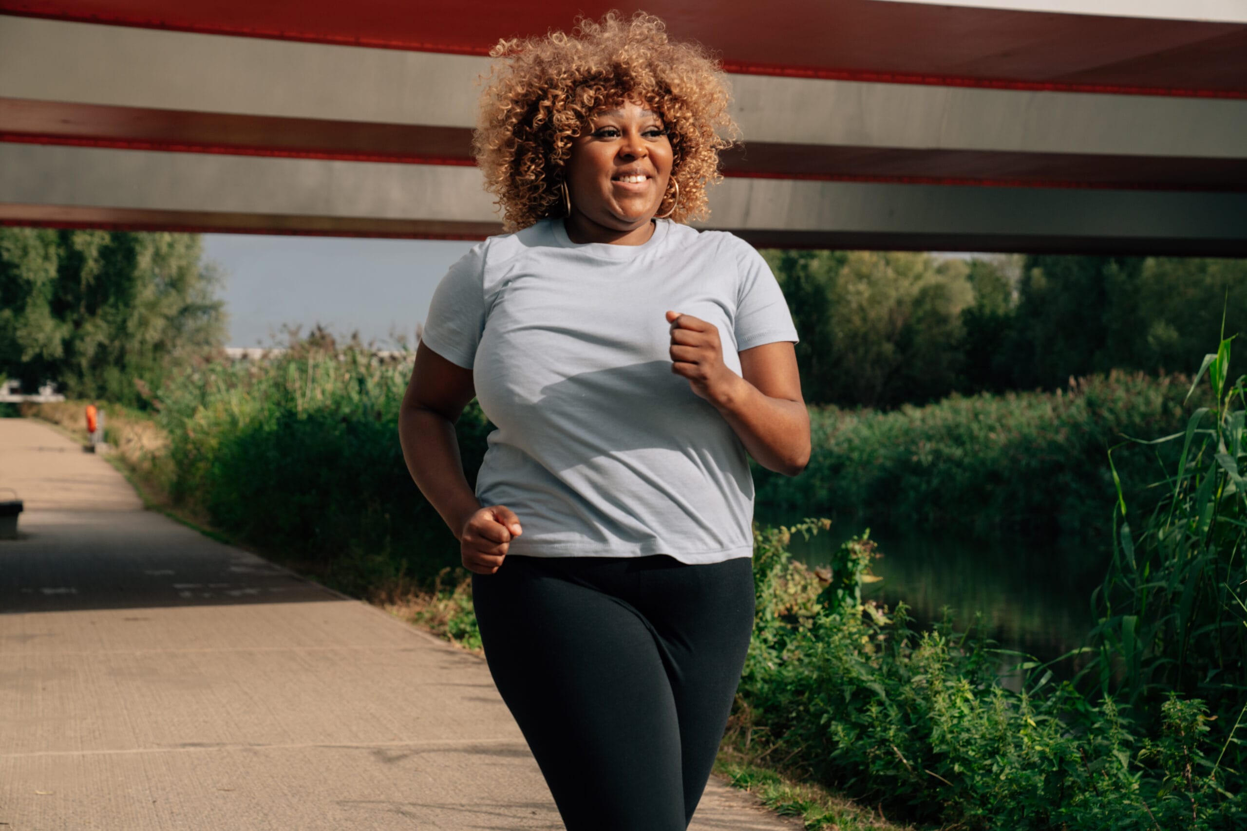 a woman running under a bridge