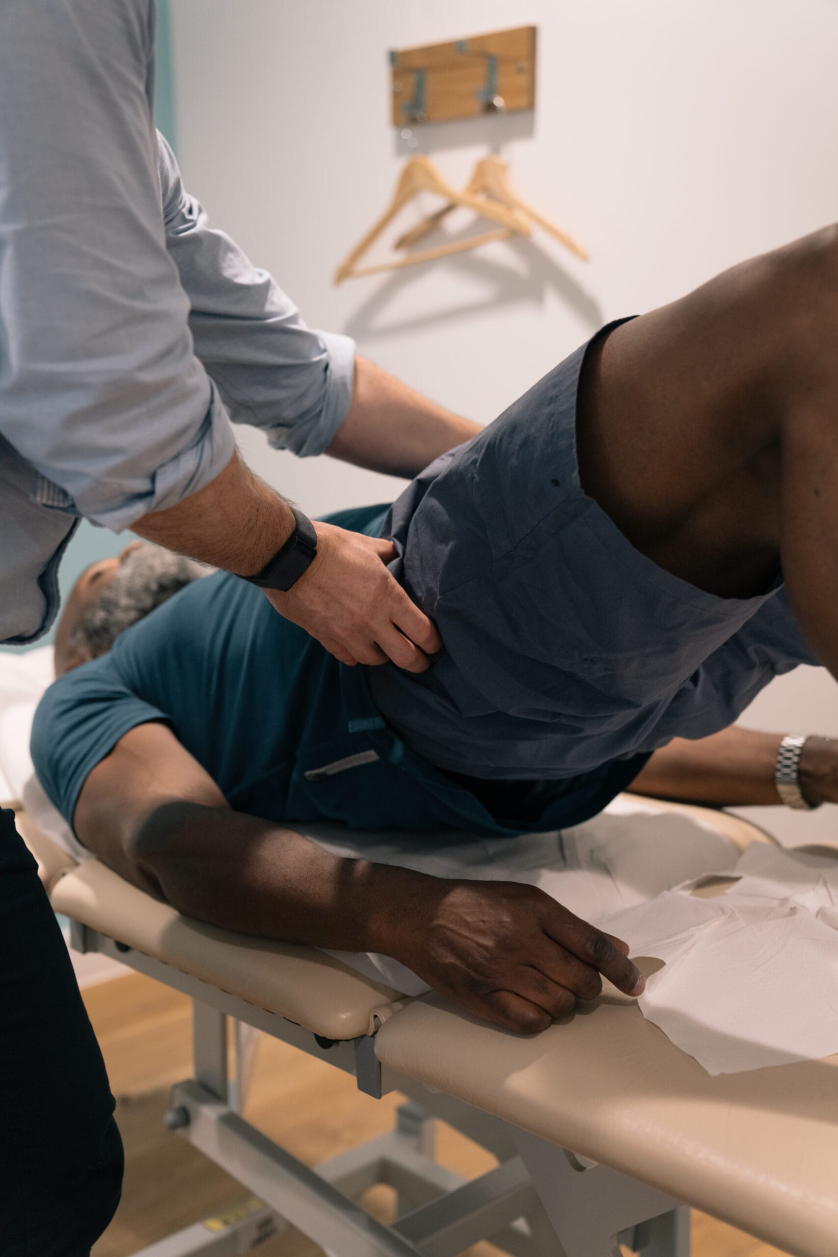 clinician supporting patient's hips in assessment