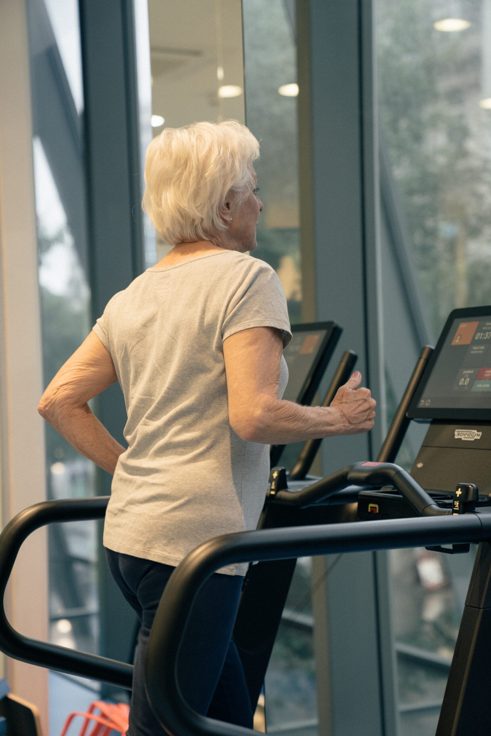 older woman running on treadmill