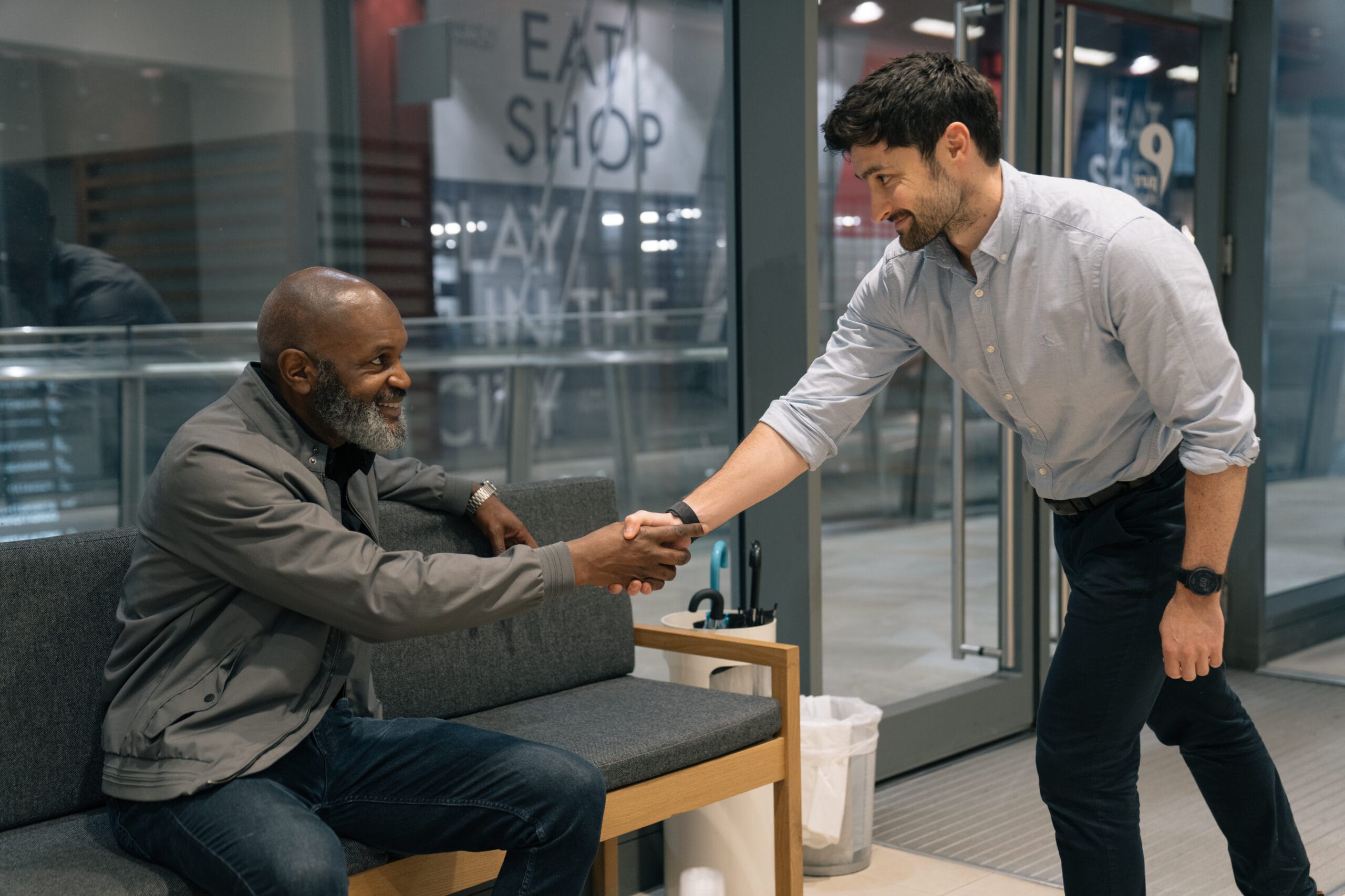 Clinician meeting and shaking the hand of a patient in waiting room