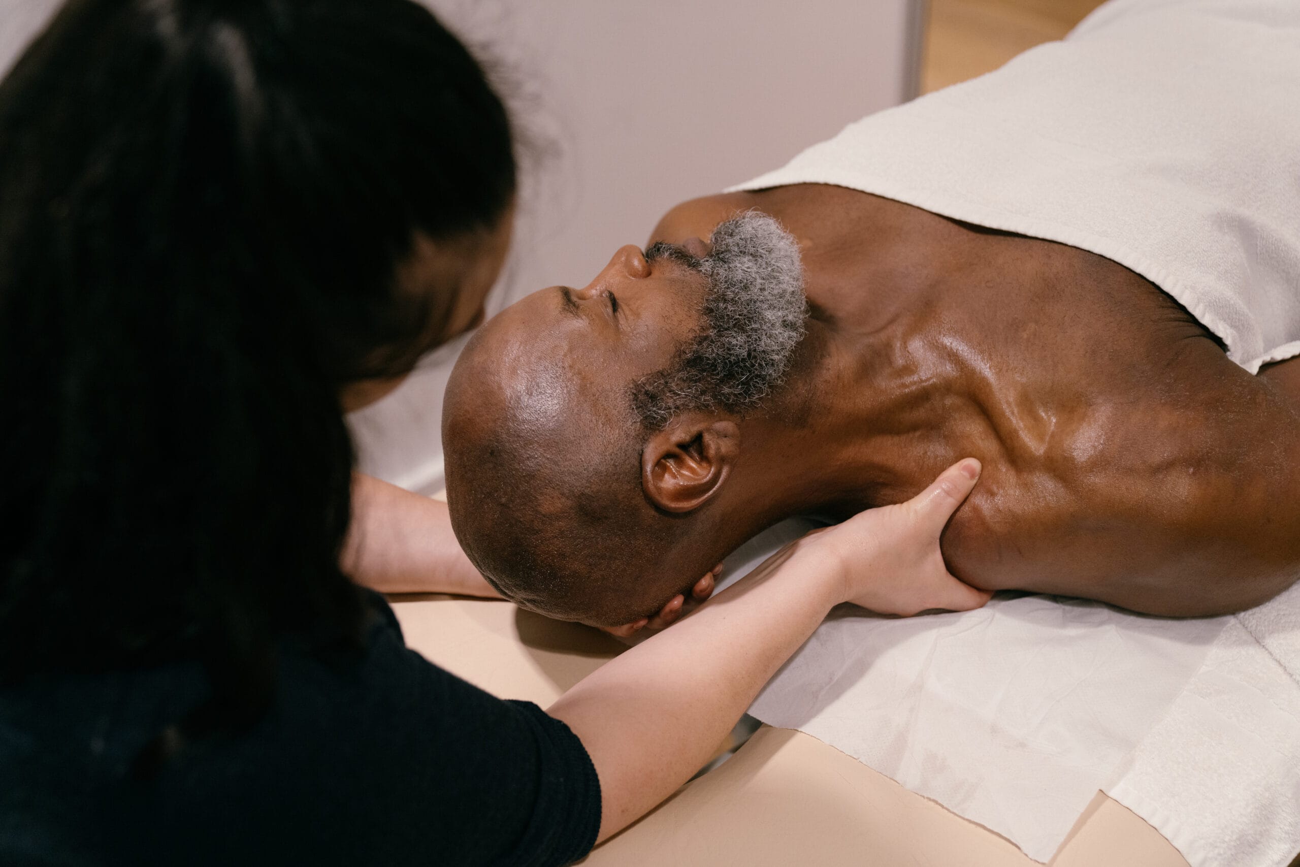 Patient face up having Soft tissue therapy on their shoulder