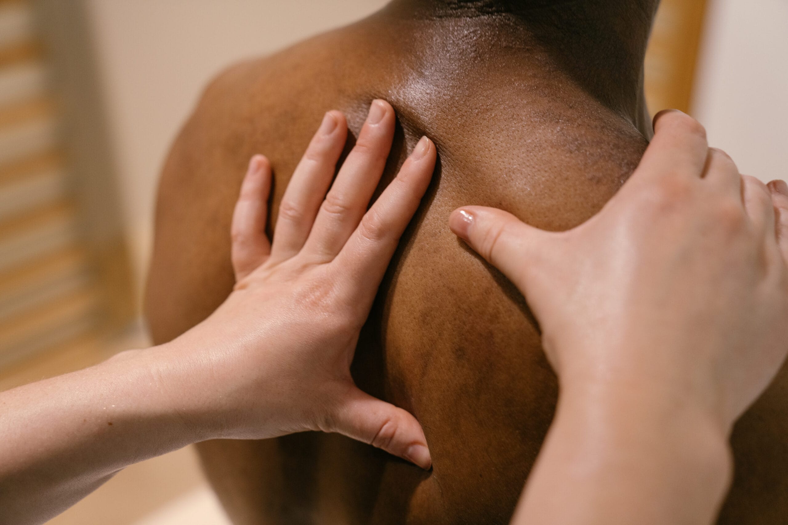 Close up of hands on patient's back sat up