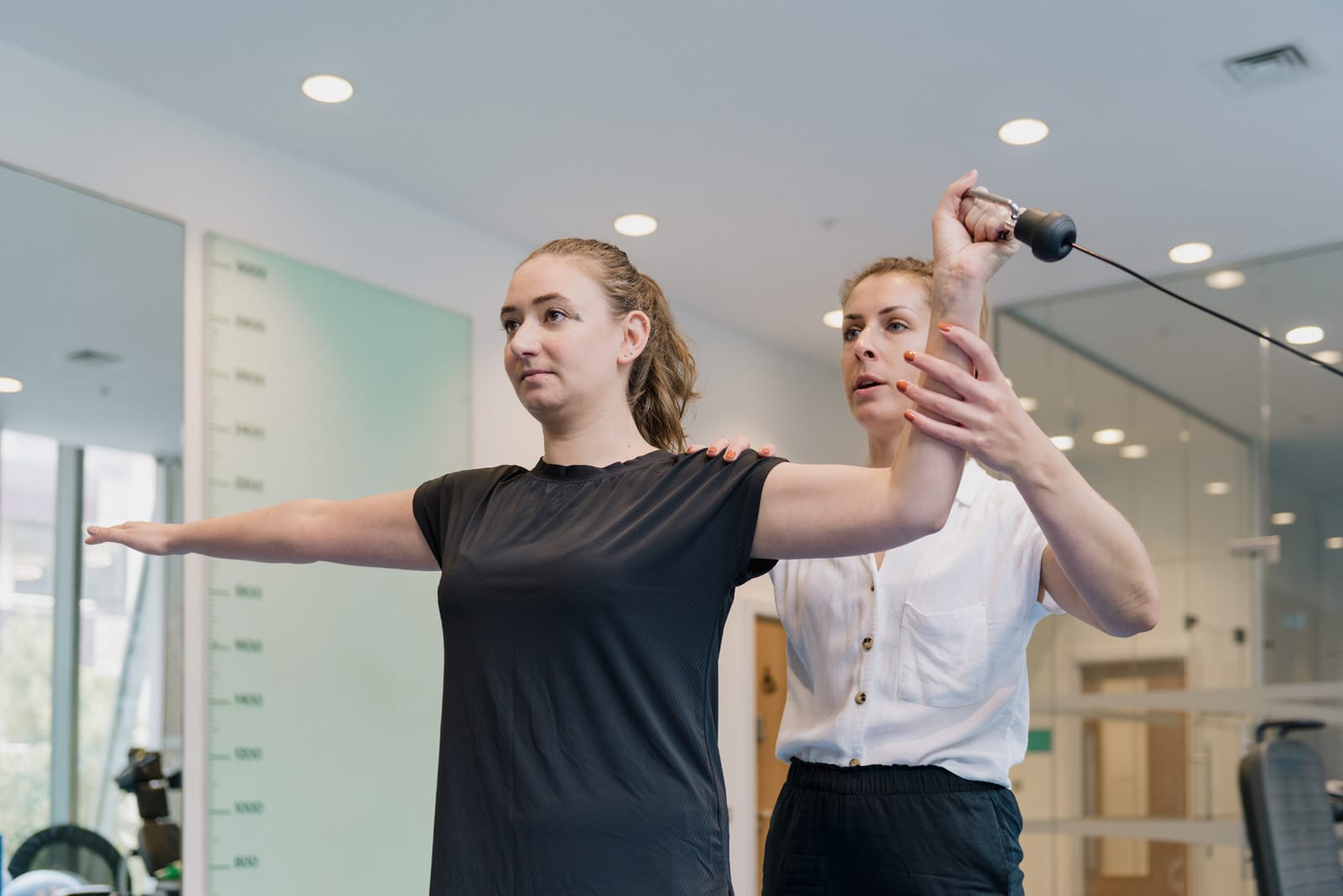clinician holding patient arm in physio gym