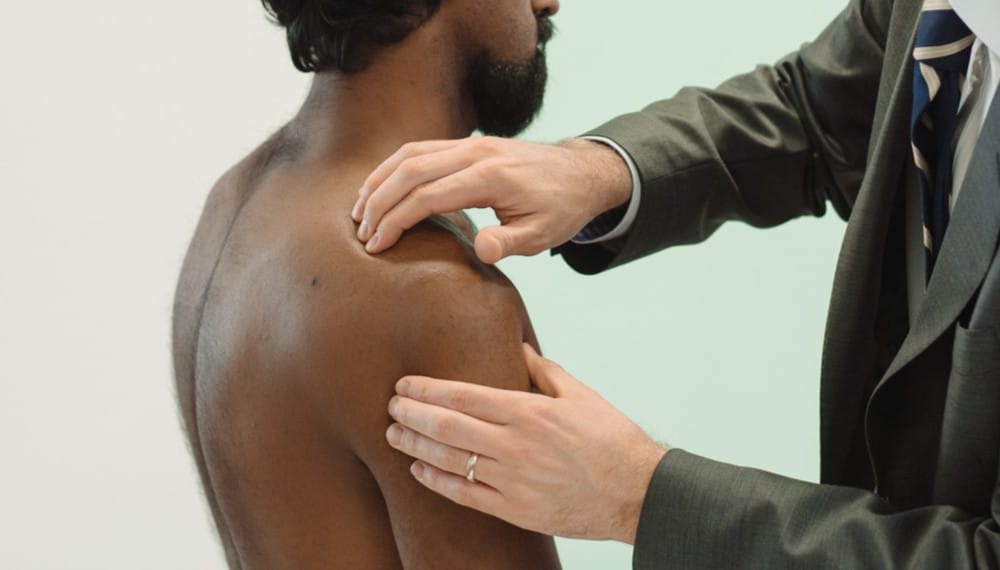 Clinician assessing patient's shoulder