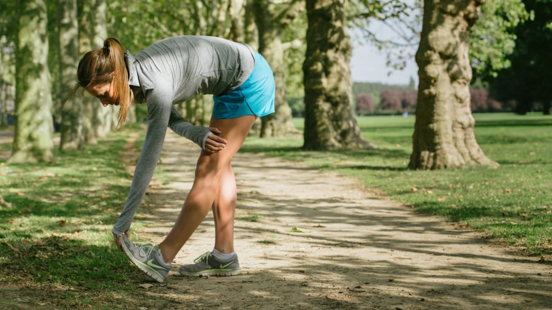 runner stretching in a park