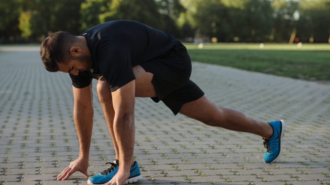 a man stretching on the floor in a park