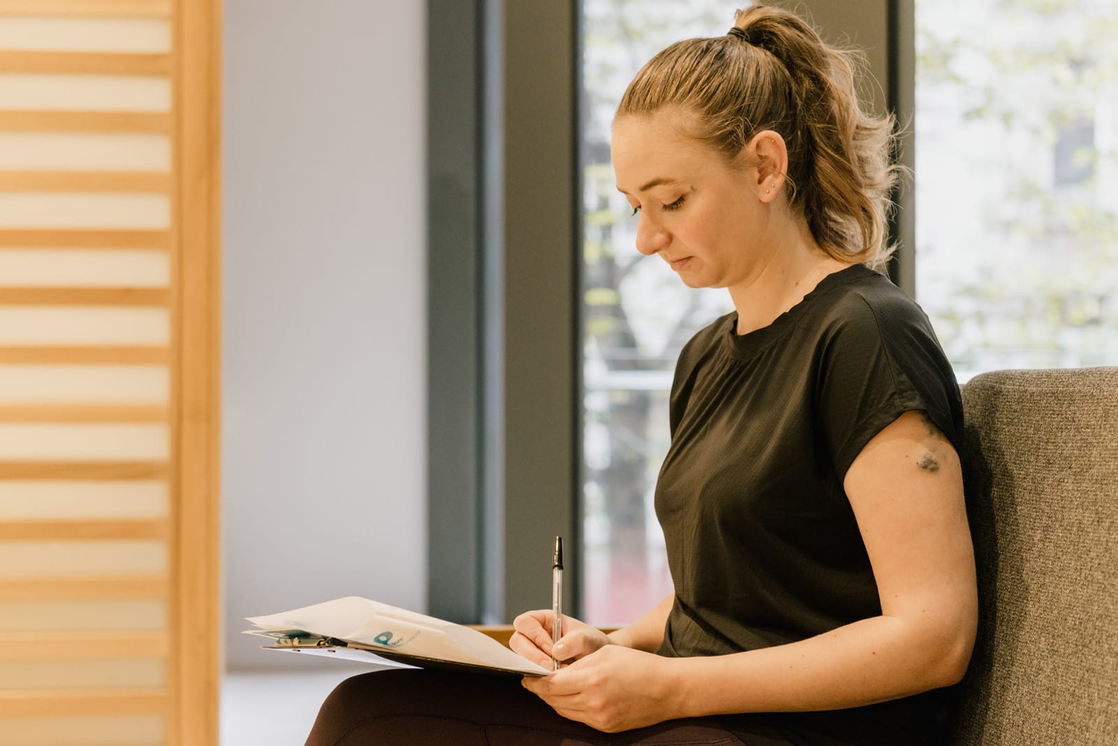 patient in waiting room with pen and form